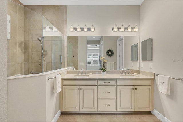 bathroom with tile patterned flooring, vanity, and tiled shower