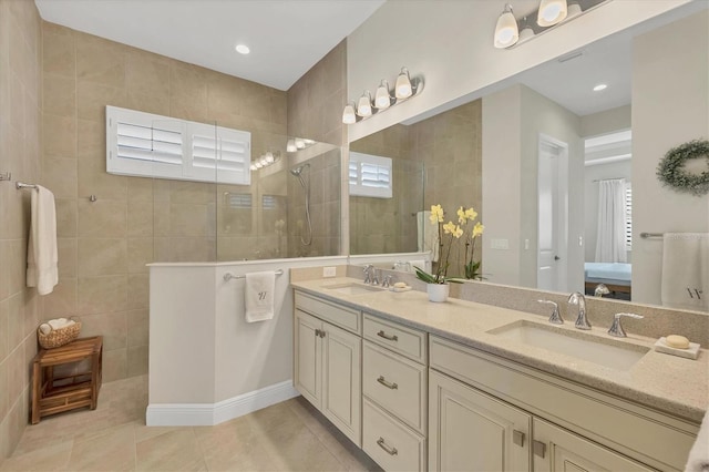 bathroom featuring tile patterned floors, a wealth of natural light, vanity, and tiled shower