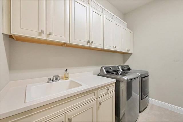 laundry area featuring cabinets, independent washer and dryer, and sink