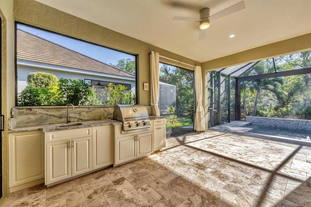 sunroom featuring ceiling fan and sink