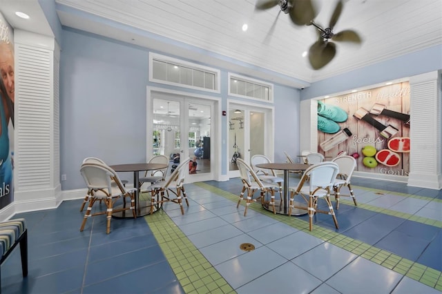 tiled dining room with ceiling fan, crown molding, and french doors