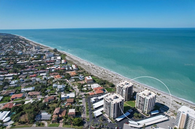 birds eye view of property with a water view and a beach view