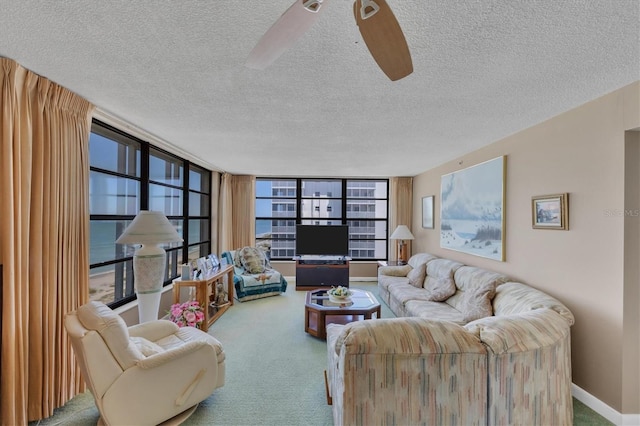 living room with light carpet, a textured ceiling, a wall of windows, and ceiling fan