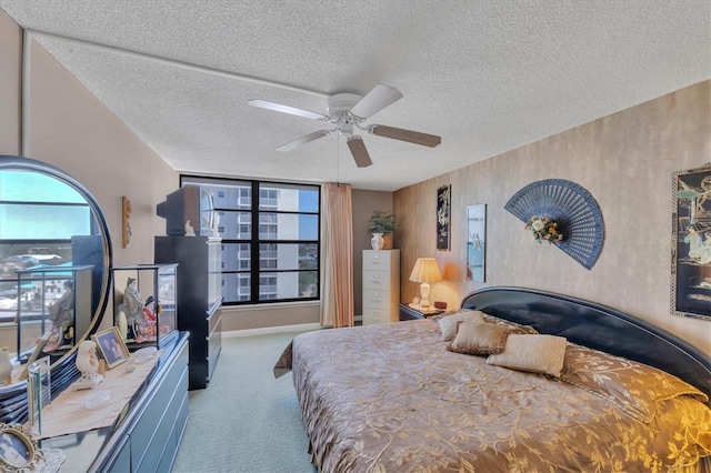 carpeted bedroom featuring a textured ceiling and ceiling fan