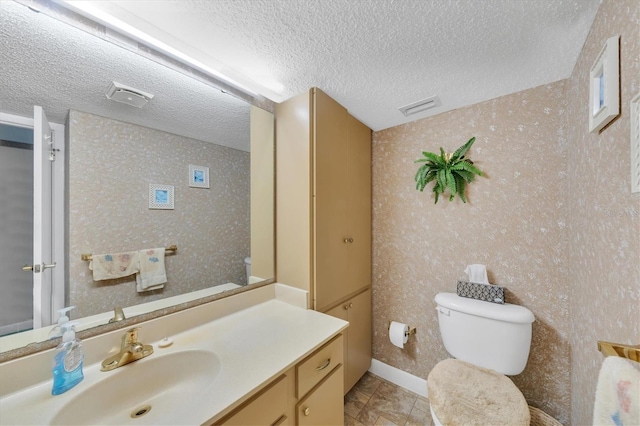 bathroom with vanity, a textured ceiling, and toilet