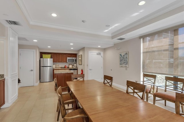 dining room with a tray ceiling and crown molding