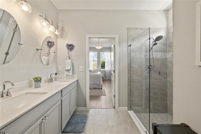 bathroom with tile patterned flooring, vanity, and tiled shower