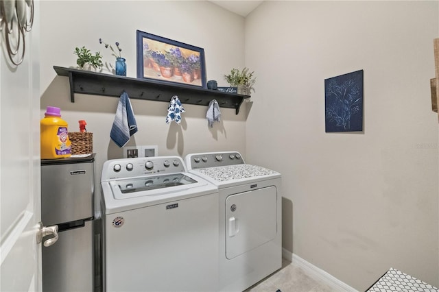 laundry room with light tile patterned floors, laundry area, independent washer and dryer, and baseboards