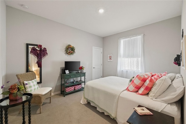 bedroom with light carpet and baseboards