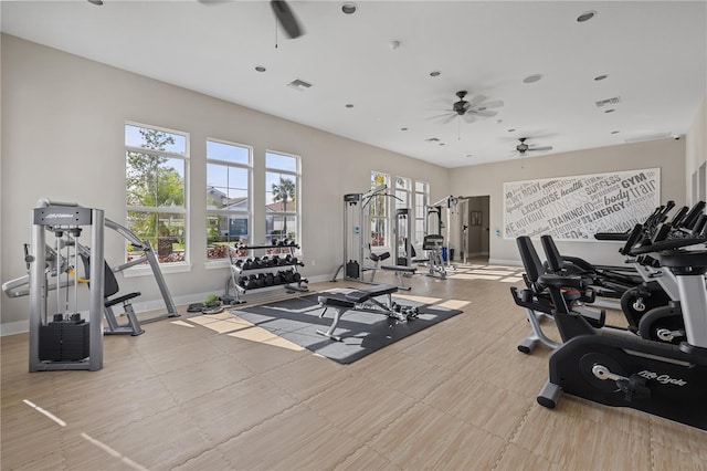 exercise room with ceiling fan, visible vents, and baseboards