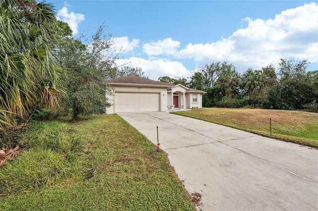 ranch-style house featuring an attached garage, concrete driveway, a front yard, and stucco siding