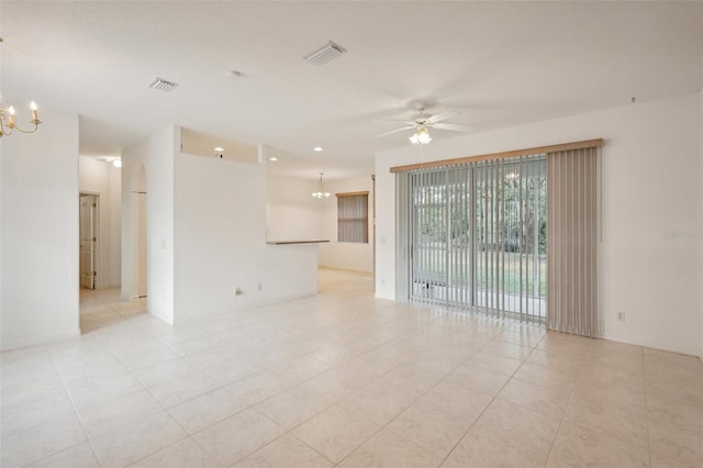 empty room with light tile patterned flooring, visible vents, and ceiling fan with notable chandelier