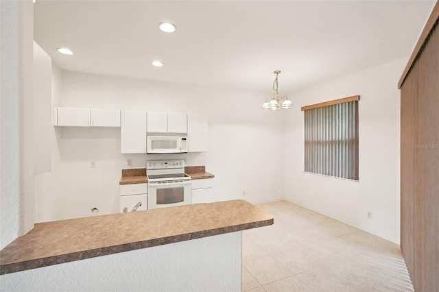 kitchen featuring white appliances, pendant lighting, white cabinets, and recessed lighting