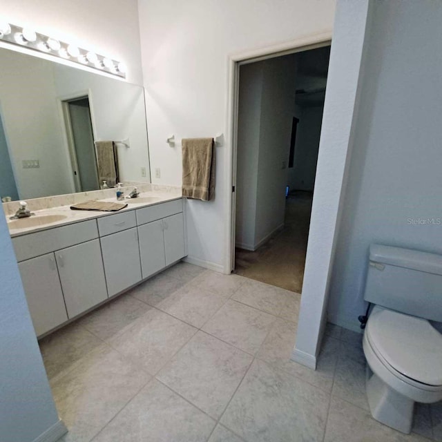 full bath featuring tile patterned flooring, a sink, toilet, and double vanity