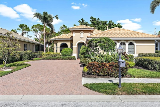 134 Savona Way N, Venice, FL 34275 - mediterranean / spanish home featuring stucco siding, a tile roof, and decorative driveway