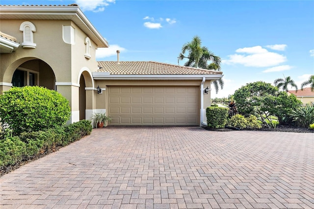 134 Savona Way N, Venice, FL 34275 - view of property exterior with stucco siding, decorative driveway, a tile roof, and a garage