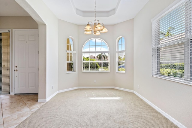 134 Savona Way N, Venice, FL 34275 - unfurnished room with a chandelier, light carpet, arched walkways, and a tray ceiling