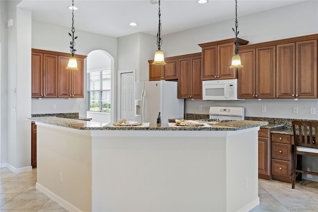 kitchen with white appliances, a center island, hanging light fixtures, and dark stone countertops