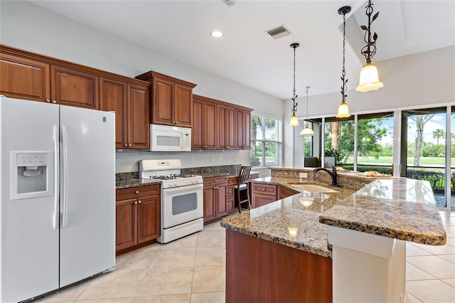 134 Savona Way N, Venice, FL 34275 - kitchen featuring white appliances, light tile patterned floors, a spacious island, brown cabinets, and dark stone counters