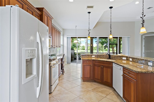 134 Savona Way N, Venice, FL 34275 - kitchen with white appliances, brown cabinetry, healthy amount of natural light, light tile patterned floors, and recessed lighting