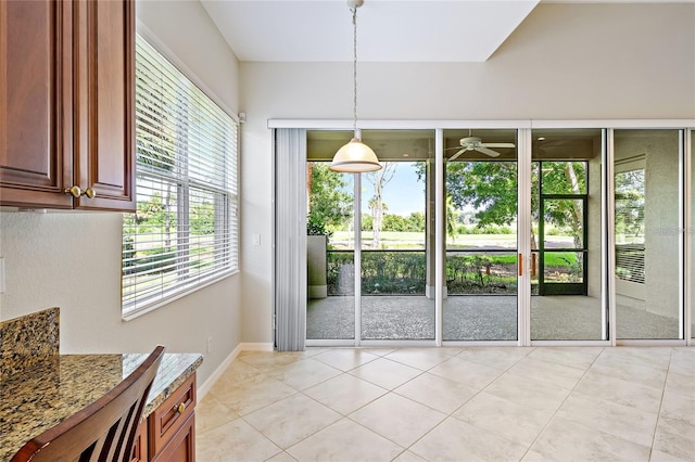 interior space featuring ceiling fan, light tile patterned flooring, and a healthy amount of sunlight