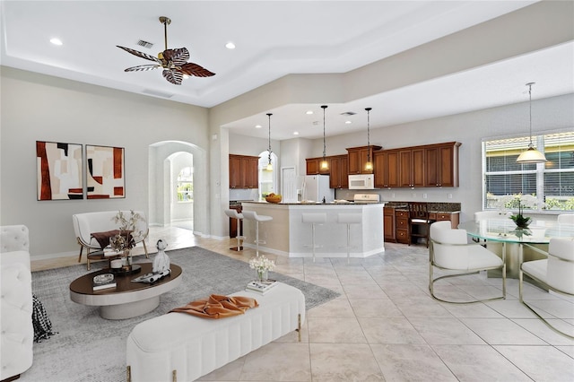 tiled living room featuring a towering ceiling and ceiling fan