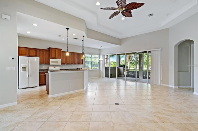 kitchen featuring a center island, white appliances, ceiling fan, light tile patterned floors, and decorative light fixtures