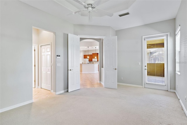 134 Savona Way N, Venice, FL 34275 - unfurnished bedroom featuring light carpet, arched walkways, freestanding refrigerator, ensuite bath, and access to exterior