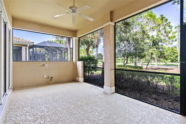 unfurnished sunroom featuring ceiling fan