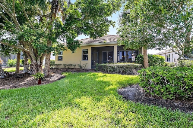 134 Savona Way N, Venice, FL 34275 - back of house with stucco siding, a tiled roof, a lawn, and a sunroom