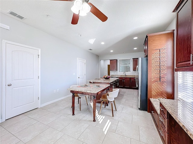 tiled dining area featuring ceiling fan and sink