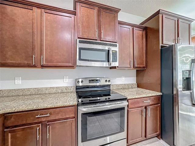 kitchen with a textured ceiling and appliances with stainless steel finishes