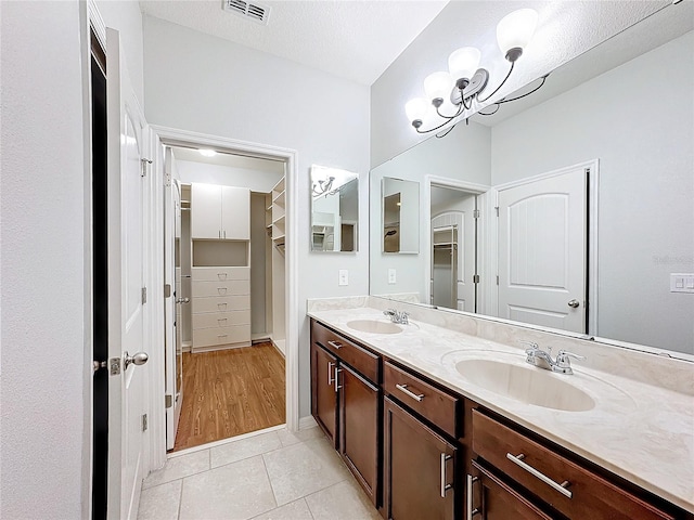 bathroom featuring a textured ceiling, vanity, tile patterned floors, and a notable chandelier