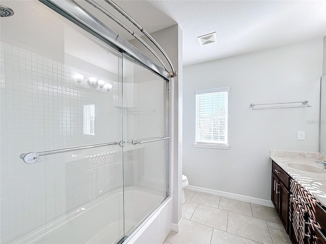 full bathroom featuring vanity, shower / bath combination with glass door, tile patterned flooring, toilet, and a textured ceiling