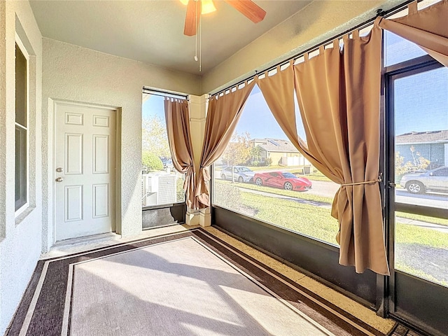 unfurnished sunroom with ceiling fan