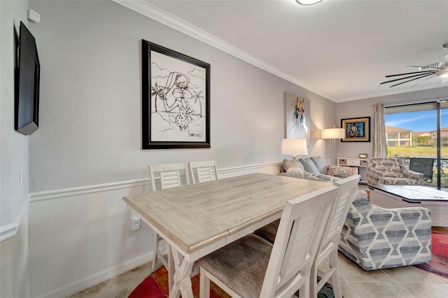 tiled dining room with ceiling fan and crown molding