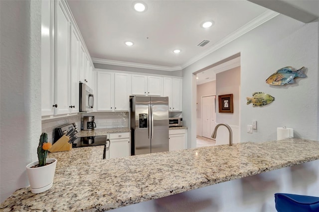 kitchen with kitchen peninsula, white cabinets, and stainless steel appliances