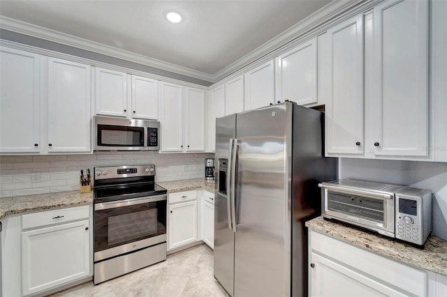 kitchen with white cabinets, stainless steel appliances, and light stone countertops