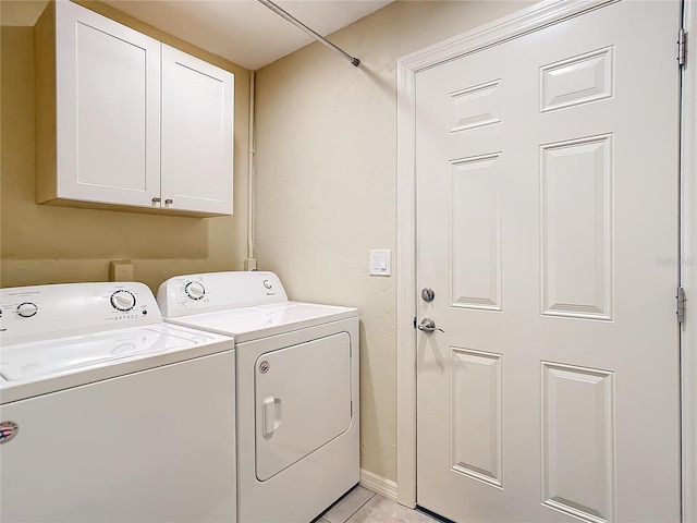 laundry area with light tile patterned floors, cabinets, and independent washer and dryer