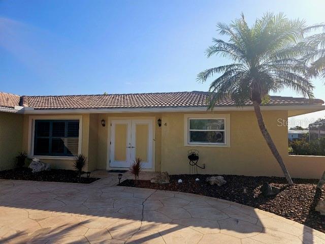 4 Windsor Dr, Englewood, FL 34223 - rear view of property with stucco siding and a tiled roof