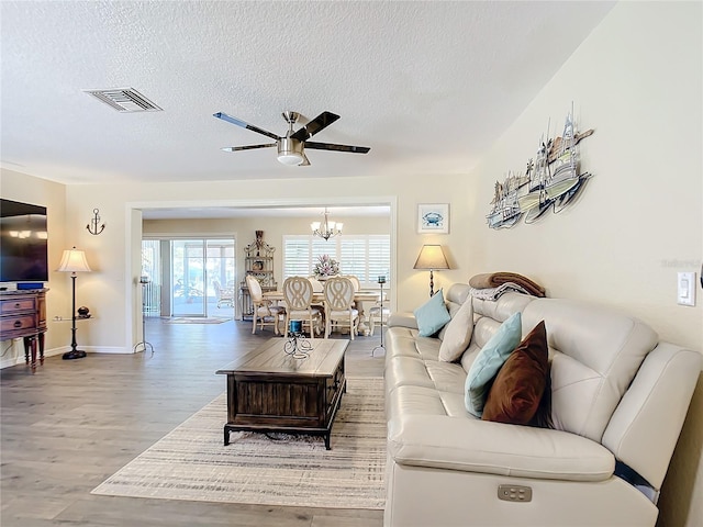 4 Windsor Dr, Englewood, FL 34223 - living room with visible vents, a textured ceiling, wood finished floors, and ceiling fan with notable chandelier