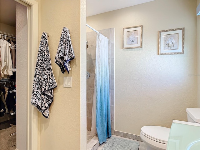 4 Windsor Dr, Englewood, FL 34223 - bathroom with a tile shower, a textured wall, a walk in closet, and toilet