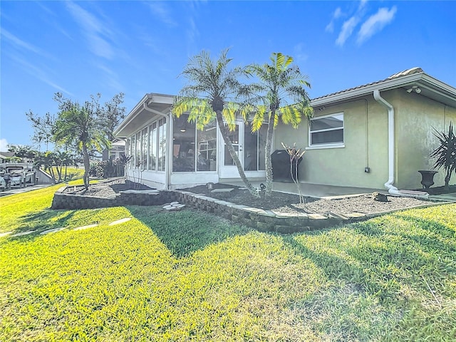 4 Windsor Dr, Englewood, FL 34223 - back of house with a yard, a sunroom, and stucco siding
