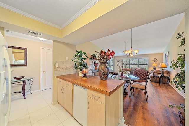 kitchen with light brown cabinets, hanging light fixtures, light wood-type flooring, ornamental molding, and a notable chandelier