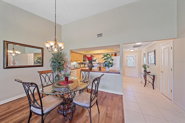 dining space with a chandelier and light hardwood / wood-style floors