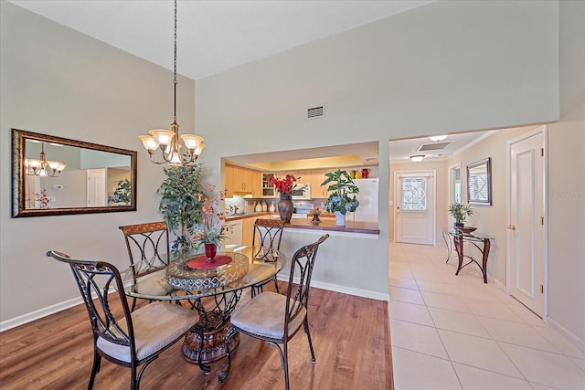 1211 Capri Isles Blvd Unit 58, Venice, FL 34292 - dining area featuring light wood-type flooring, a chandelier, and a high ceiling