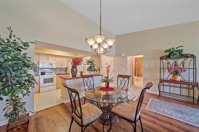 1211 Capri Isles Blvd Unit 58, Venice, FL 34292 - dining area with high vaulted ceiling, a chandelier, and light wood-style floors