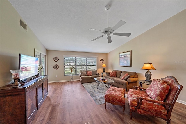 living room featuring ceiling fan, plenty of natural light, lofted ceiling, and hardwood / wood-style flooring