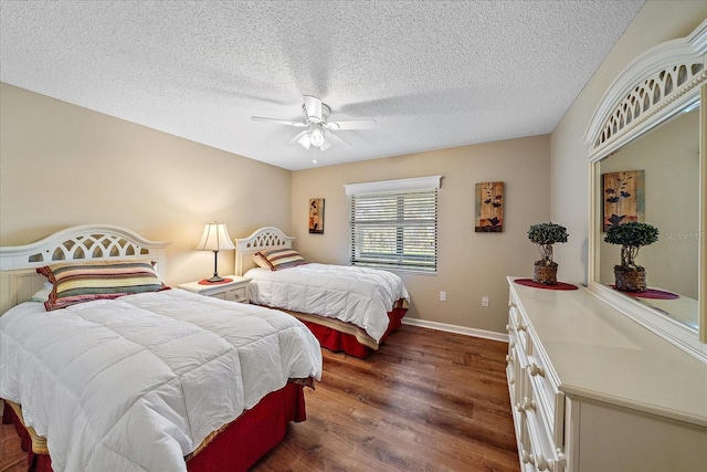 bedroom with a textured ceiling, ceiling fan, and dark wood-type flooring