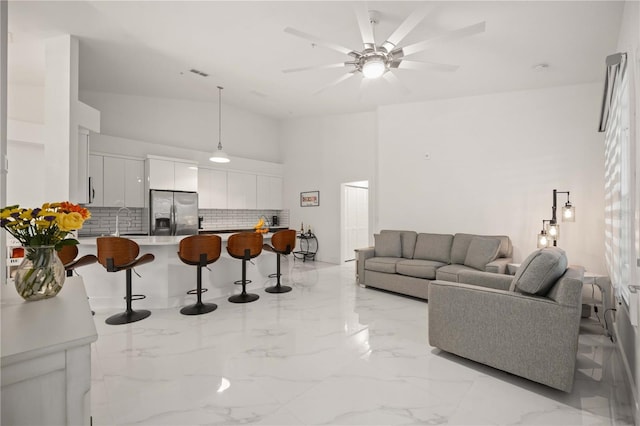 living room featuring ceiling fan and sink